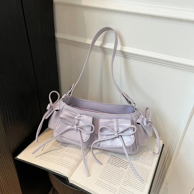 Women's tassel bow shoulder bag in pleated design with multiple pockets, shown in a selected colour.