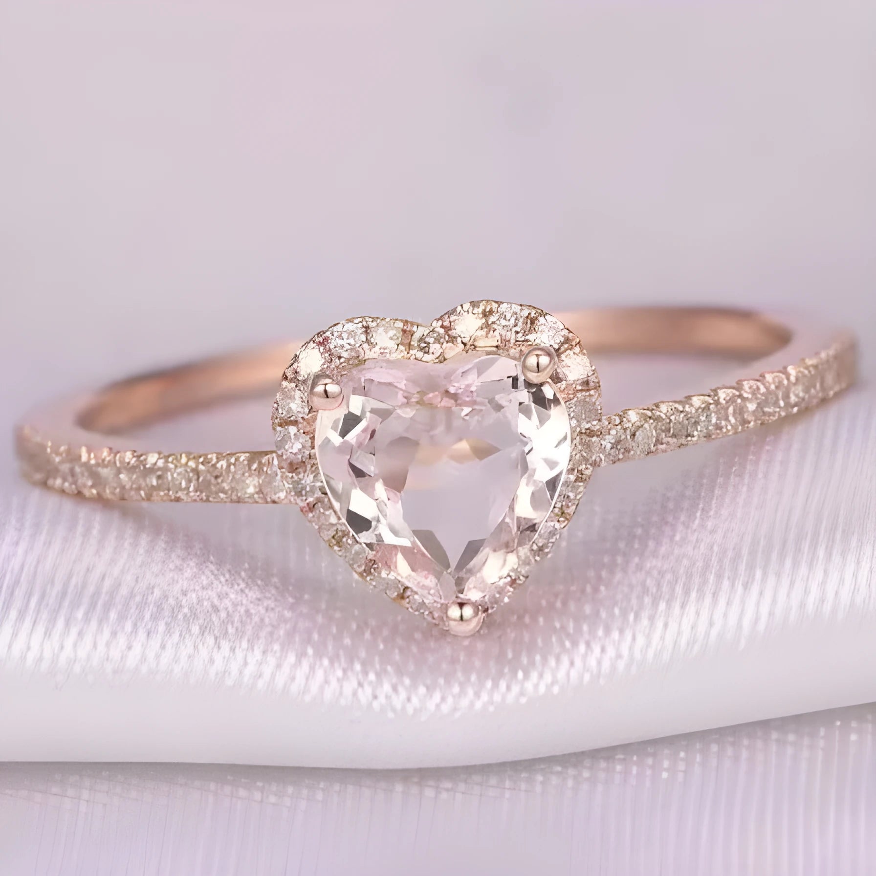 Women's heart-shaped crystal wedding ring in rose gold or silvery on a white background.