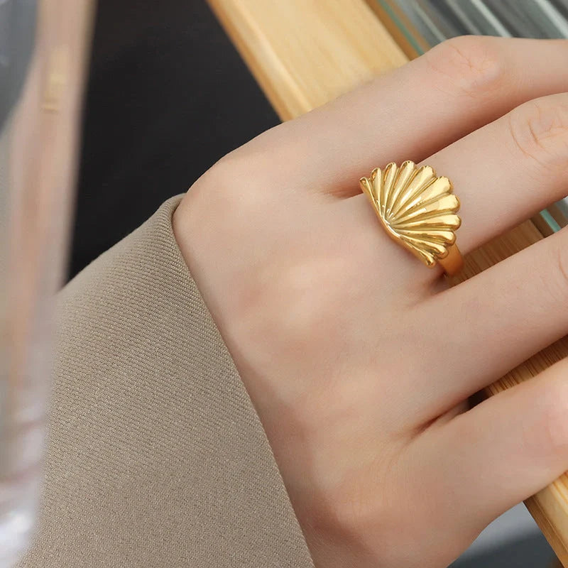 Elegant scallop-inspired titanium steel ring in steel or gold finish, available in sizes 6, 7, and 8, featuring a unique geometric design for a stylish and versatile accessory.