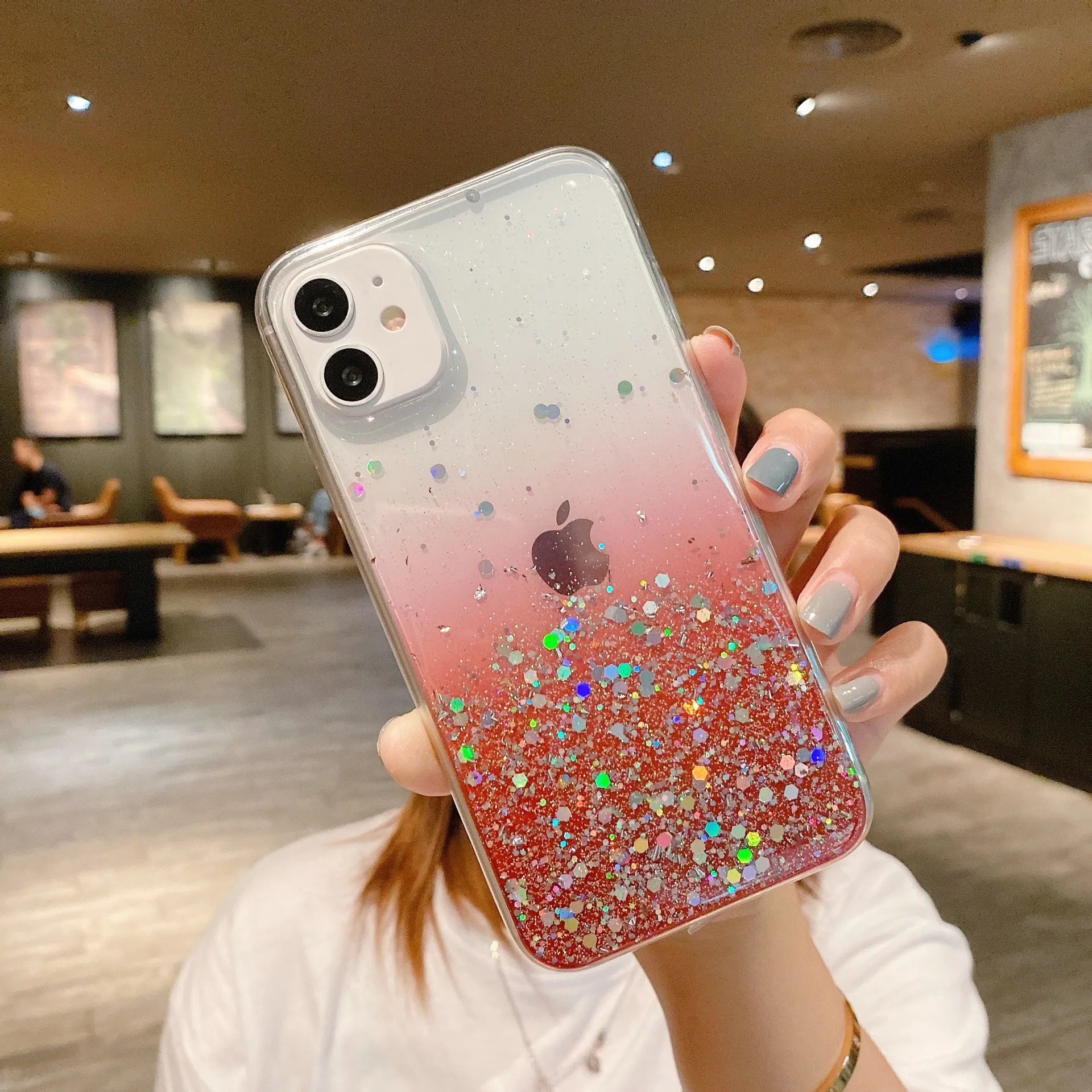 Transparent glitter epoxy soft shell case for Apple iPhone on a table.