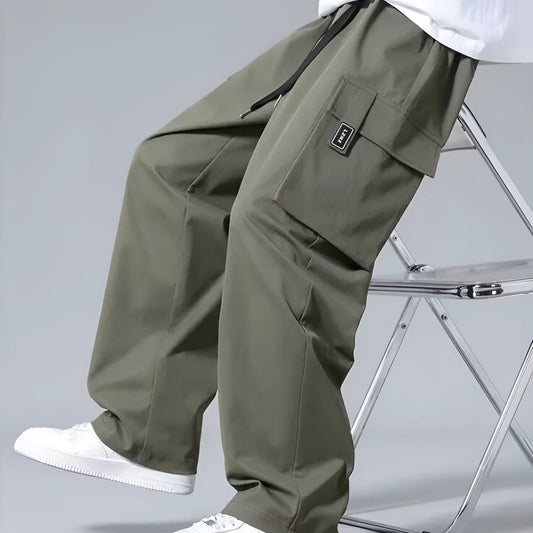 Boys in straight leg cargo trousers with drawstring waist and large side pockets, shown in Army Green.