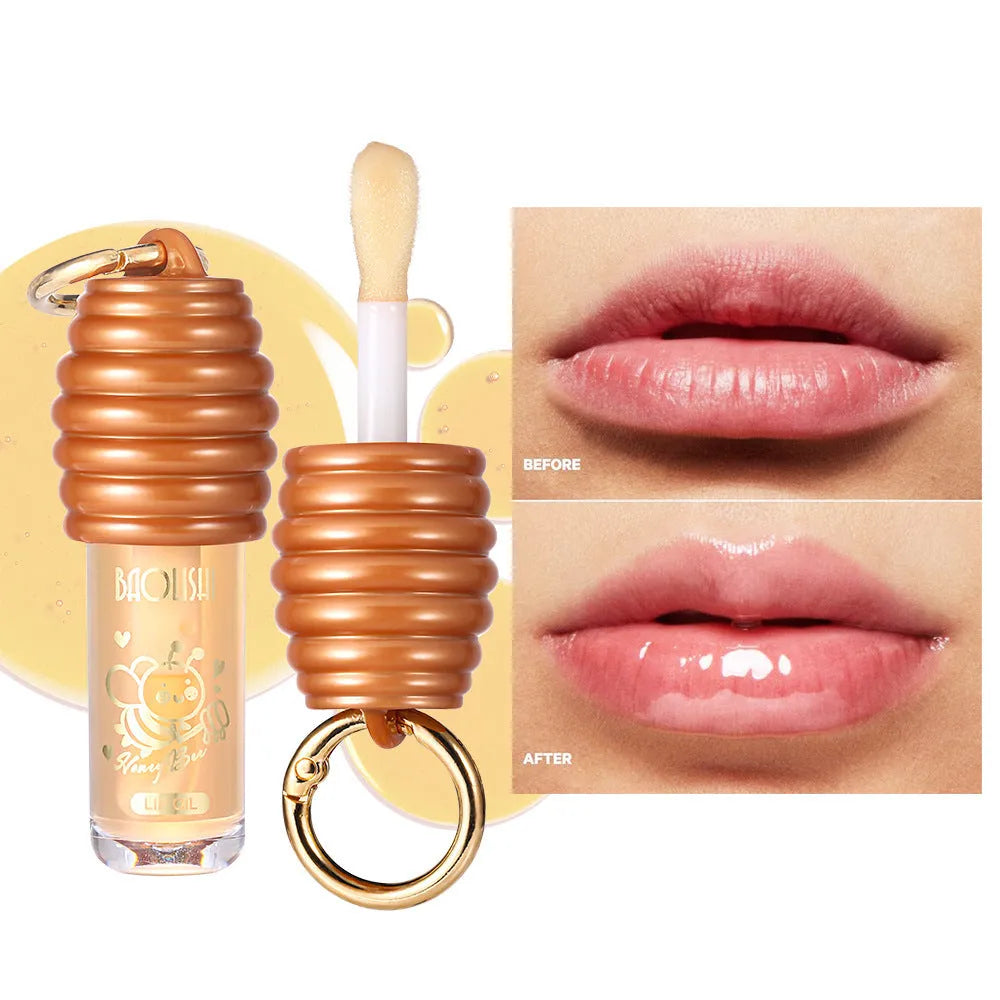 Moisturising honey lip gloss on a silver keychain against a plain background.