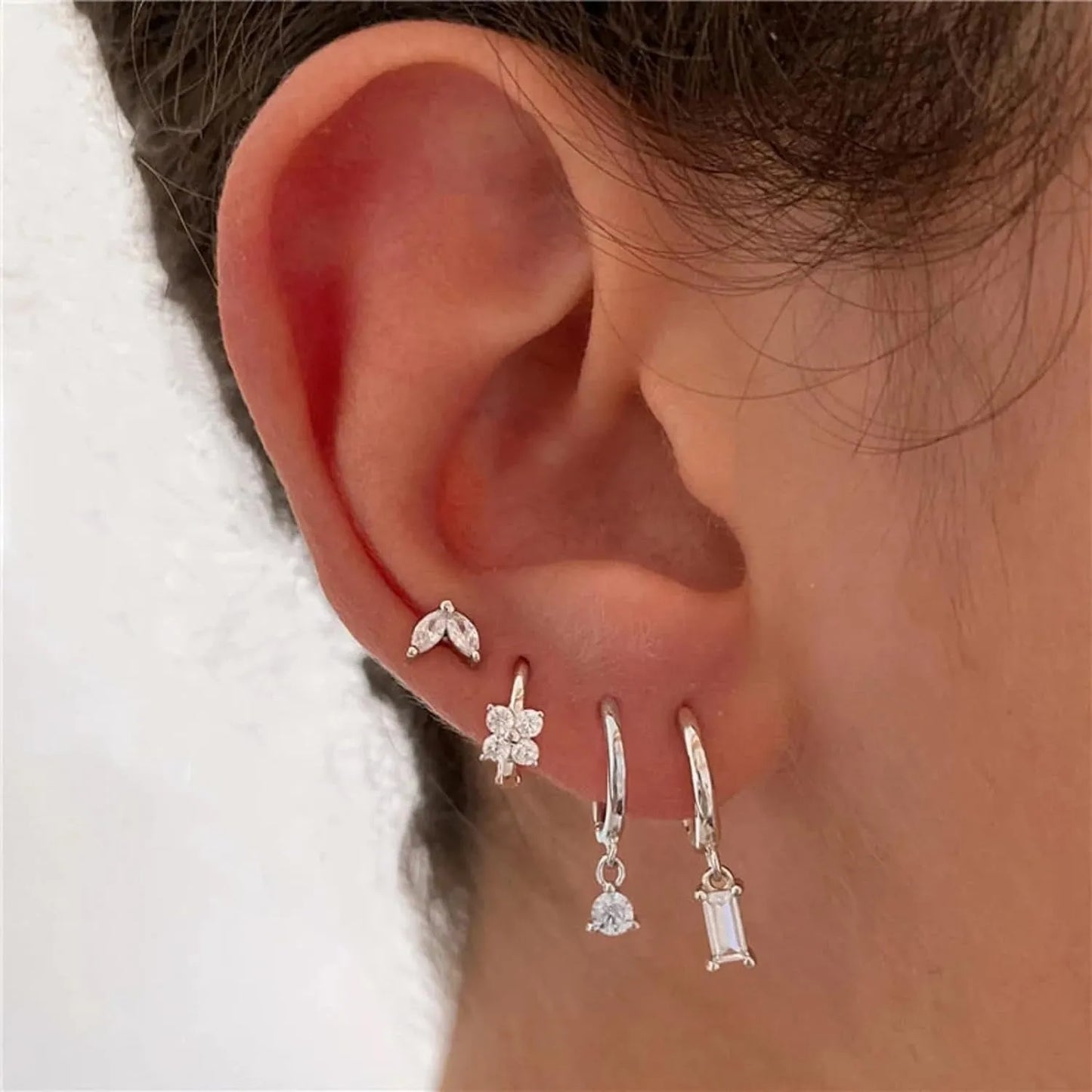 A set of geometric and star-shaped copper earrings with zircon accents in gold or silver plating.