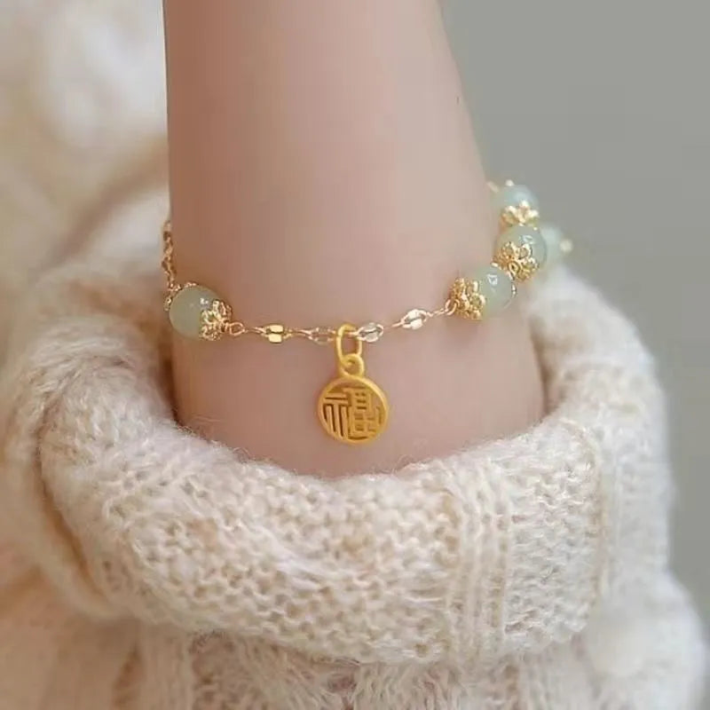 Chinese style glass bead bracelet with bamboo joint design on wrist.