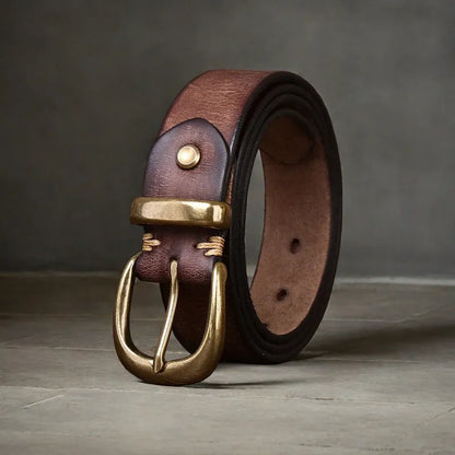 Men's black genuine cattlehide leather belt with a copper pin buckle on a jeans background.