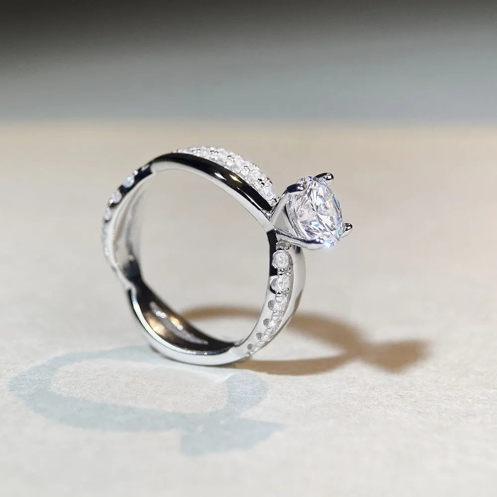 Geometric silver ring with 1 karat moissanite centre stone in four-claw setting and twisted arm band design