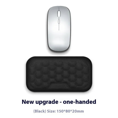 Black and grey memory foam mouse wrist rests with cloth and leather-style covers on a desk.