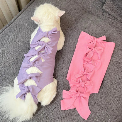 Lace-up cat sterilisation clothing in five colours including pink, purple, blue, brown, and green pineapple, showing adjustable fastening