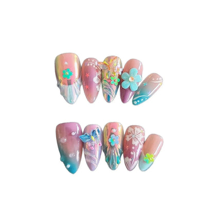 Handmade small 3D nail art sculptures showing embossed butterflies and flowers in almond shapes on a manicure.