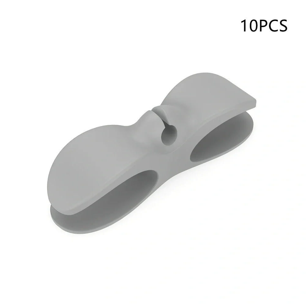 Black TPU cable organizer clips winding appliance cords on kitchen counter, 5cm size, non-marking adhesive for tidy management