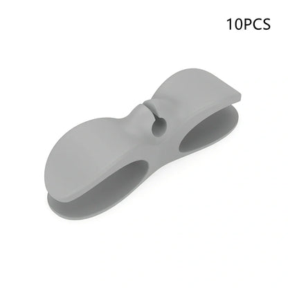 Black TPU cable organizer clips winding appliance cords on kitchen counter, 5cm size, non-marking adhesive for tidy management