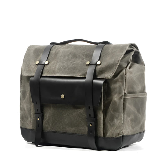 Camel Bag Knight retro cotton messenger bag in army green, showing front flap, rivet details, and size next to a motorcycle helmet.