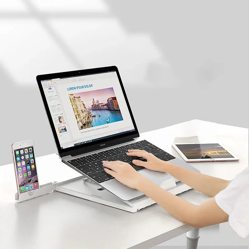 Foldable aluminium laptop stand in black or white, 280 x 280 x 25.5mm, with 9 adjustable angles and cooling slot.