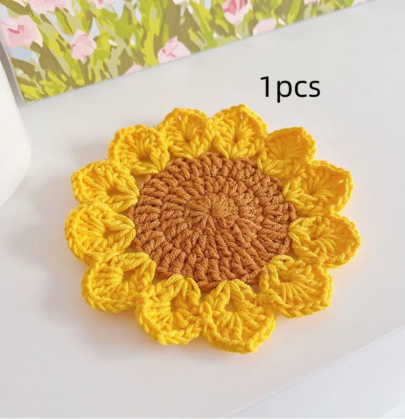 Hand-woven wool flower coaster on a wooden table