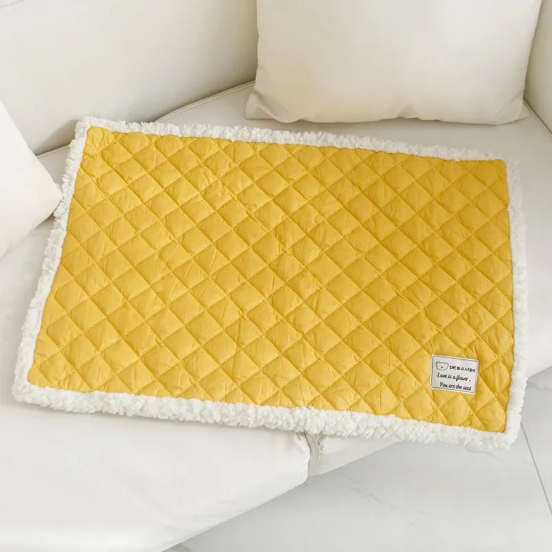 Quilted terry cloth pet blanket for cats in blue, grey, pink, or yellow colour on a pet bed.