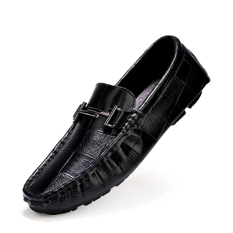 Men's brown leather casual shoes with a belt buckle on the upper, shown on a wooden surface.