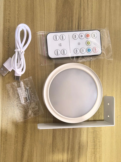 Black magnetic LED painting lamp with remote control on a white wall.