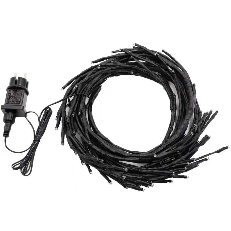 Flexible DIY willow vine LED light garland with warm white lights shaped on a wall.