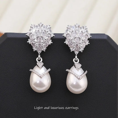 Women's drop-shaped freshwater pearl earrings with zircon inlay on 18K gold-plated settings.