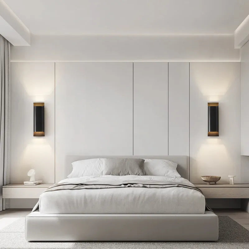 Minimalist copper wall lamp in black gold finish mounted beside bed