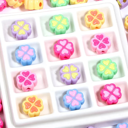 Assorted frosted acrylic four-leaf clover shaped beads in pink, green, and yellow, 15mm diameter.