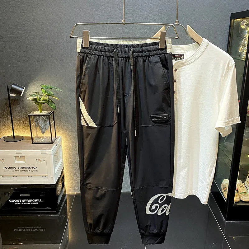 Black men's casual cotton trousers with a cropped, ankle-banded leg design on a neutral background.