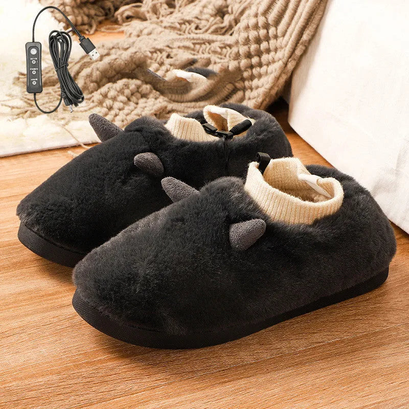 USB-powered electric slippers in black with a connected USB cable, showing soft velvet upper and plastic sole.