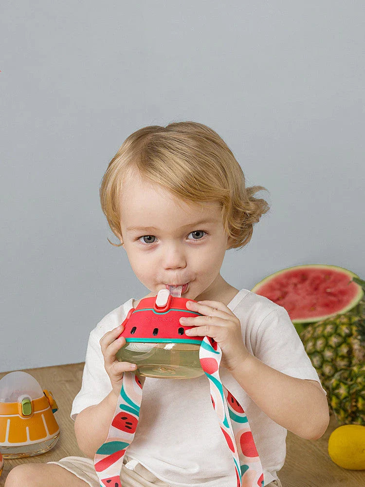 Colorful spill-proof kids water bottle with straw, featuring a shoulder strap and clear tick marks for monitoring water intake