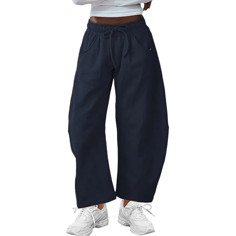 Loose fit cropped sweatpants in apricot colour with drawstring waist and side pockets on a neutral background.