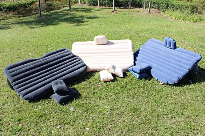 Black inflatable car bed with flocked surface and two pillows, shown folded into a chair inside a vehicle.