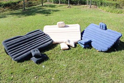 Black inflatable car bed with flocked surface and two pillows, shown folded into a chair inside a vehicle.