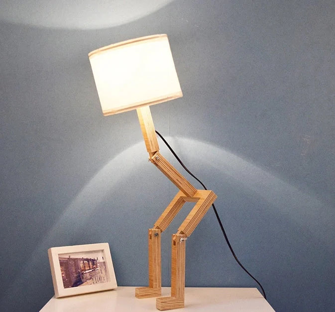 Humanoid wooden table lamp with deformable design and fabric shade for modern home decor