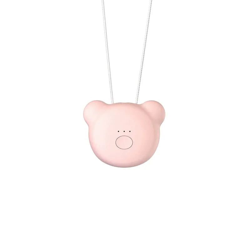 Pink wearable USB air purifier necklace on a table with USB cable, showing compact size.