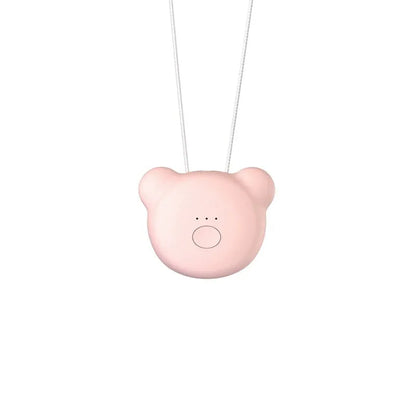 Pink wearable USB air purifier necklace on a table with USB cable, showing compact size.