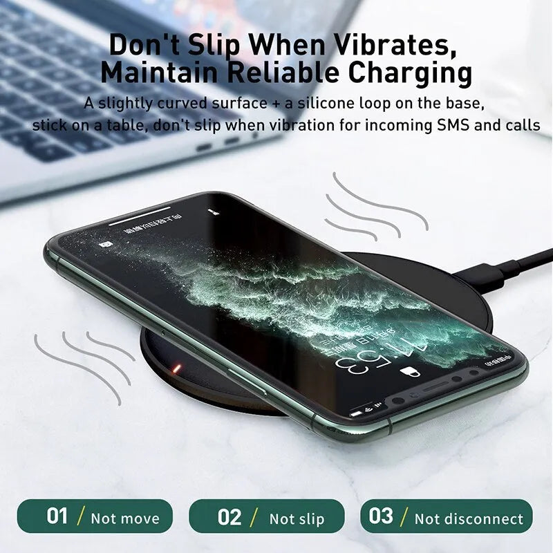 Black Baseus 15W wireless charging pad with textured silicone surface on a wooden desk.