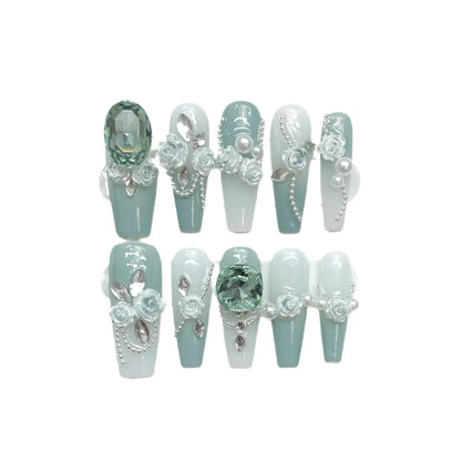 Wear Armor Green nail art set with pink camellia gradient crystal bows, butterflies, and chains arranged on a white plastic armour suit carrier.