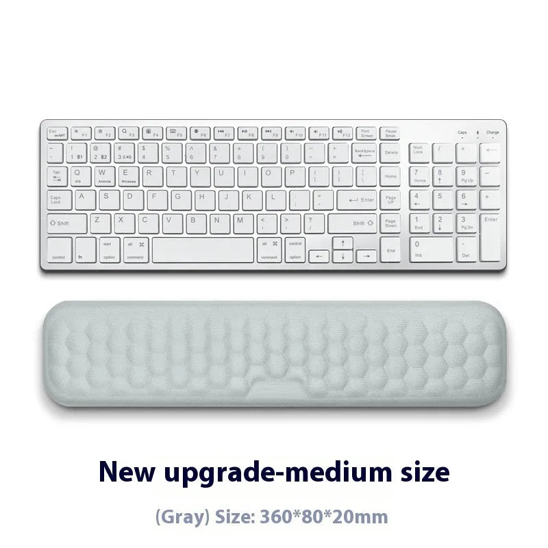 Black and grey memory foam mouse wrist rests with cloth and leather-style covers on a desk.