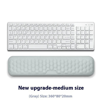 Black and grey memory foam mouse wrist rests with cloth and leather-style covers on a desk.