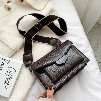 Vintage crossbody bag in black showing 20cm width, crossbody strap, and front storage compartment