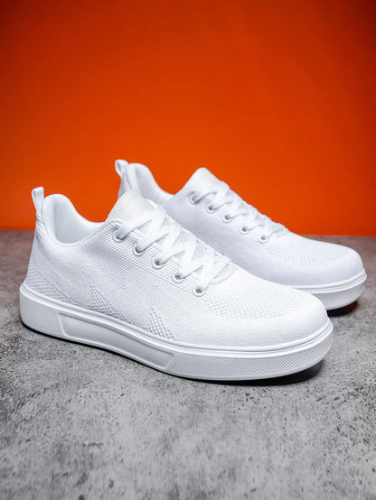 Pair of light white thick-soled casual sneakers with mesh upper and lace-up front.