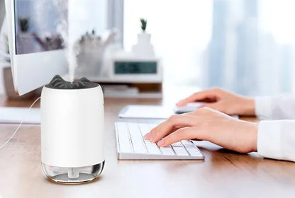 Compact cylindrical USB humidifier with night light in white, pink, or green, showing mist output.