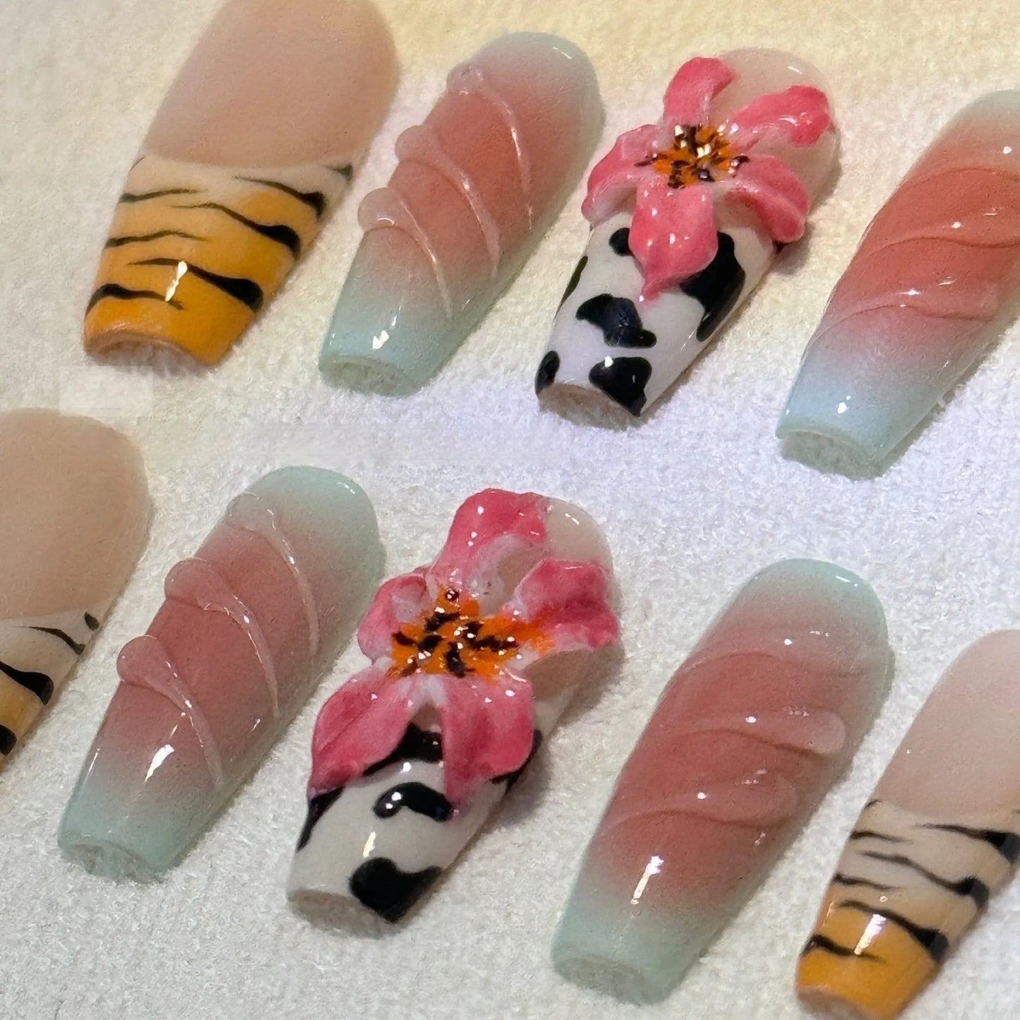 Hand-carved artificial nail art set with zebra pattern, embossed flowers, and leopard print in long length.