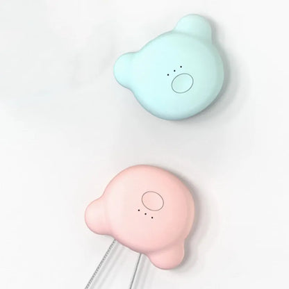 Pink wearable USB air purifier necklace on a table with USB cable, showing compact size.