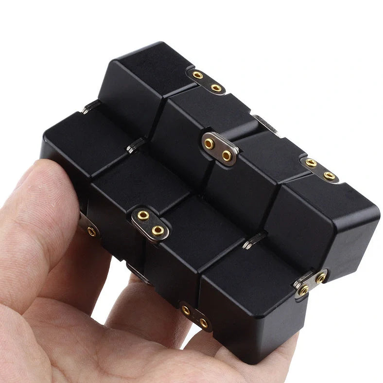 Zinc alloy Infinity Cube with eight rotating cubes showing black and silver colour options on wooden surface