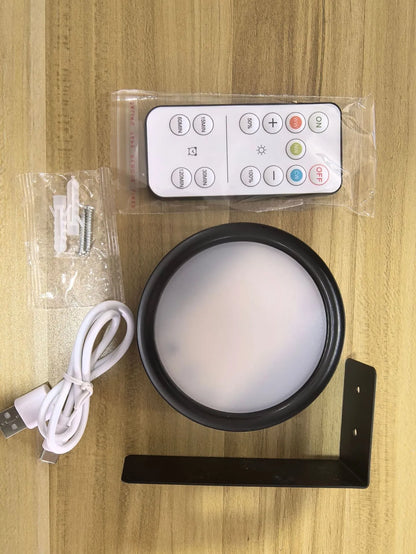 Black magnetic LED painting lamp with remote control on a white wall.