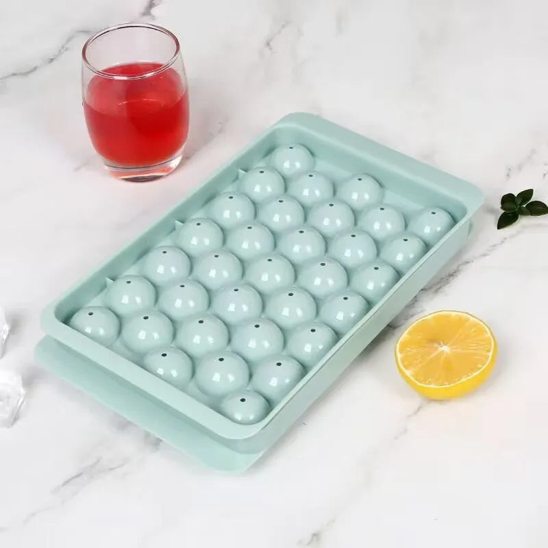 Blue silicone ice cube tray with lid showing 33 round cavities, measuring 24x14cm