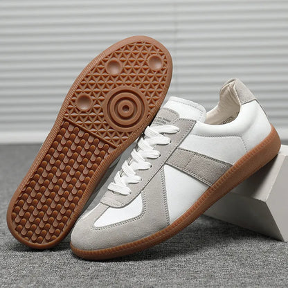 White Japanese-style retro low-top sneakers with round toe and flat rubber sole on a plain background.