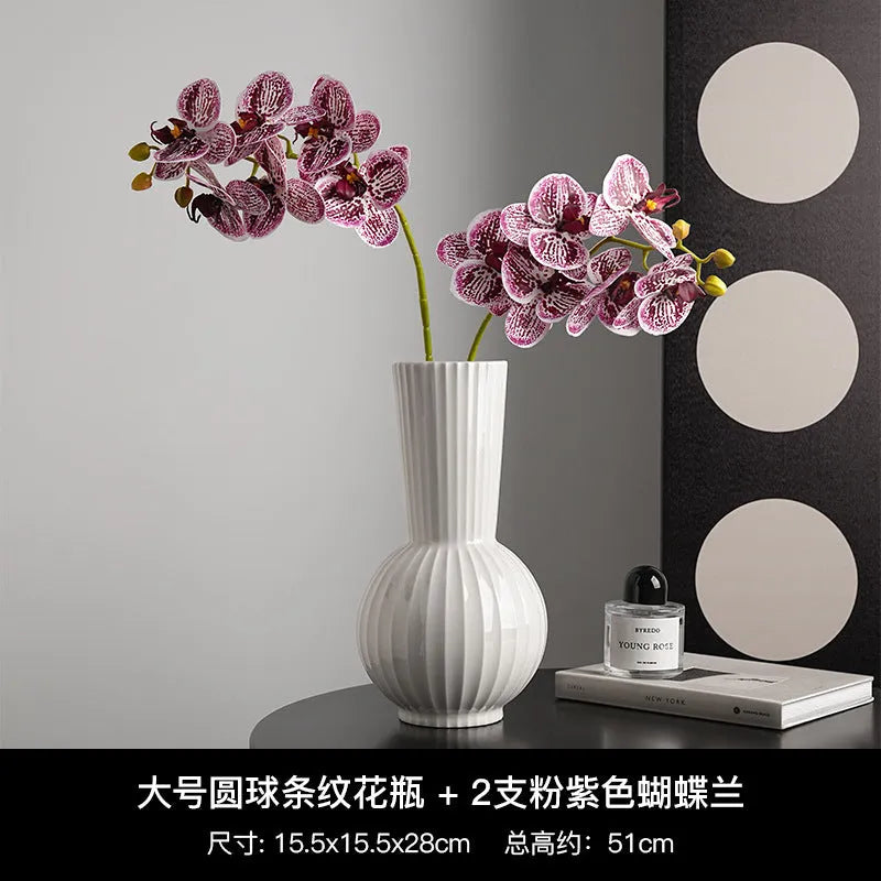 White ceramic ball-shaped vase with striped pattern, shown in small and large sizes with orchid arrangements