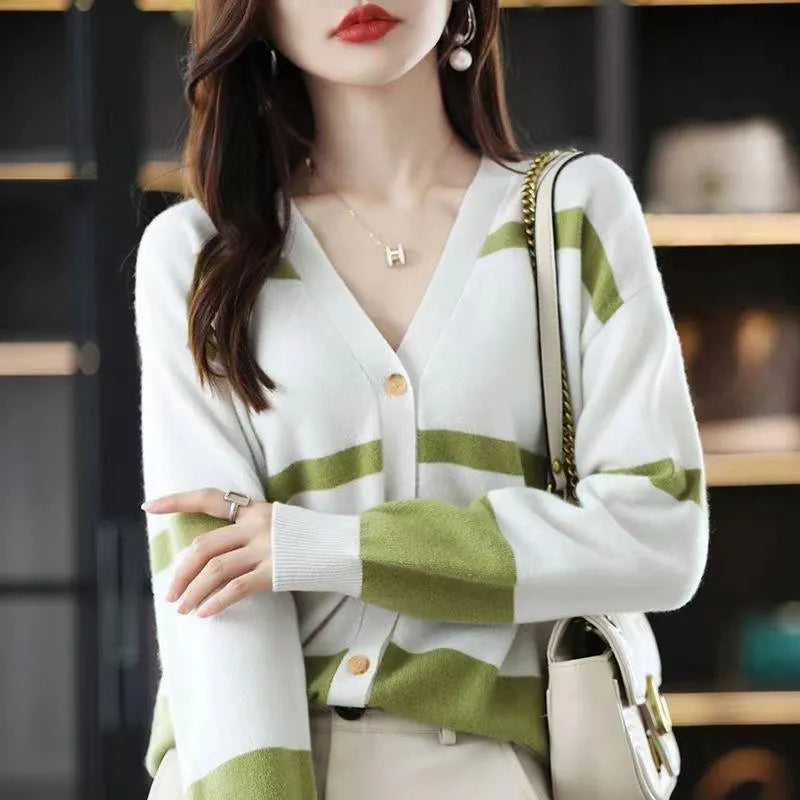 Women's black and white striped V-neck cardigan with buttons, showing a textured 3D knit pattern.