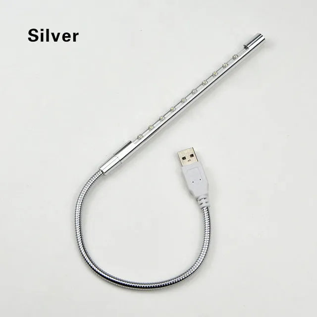 Spiral-shaped silver aluminium alloy USB LED desk lamp on a wooden table.